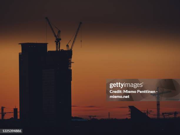 minimalistic silhouettes of urban skyline of helsinki after sunset with cranes and construction sites - work sites night stock pictures, royalty-free photos & images