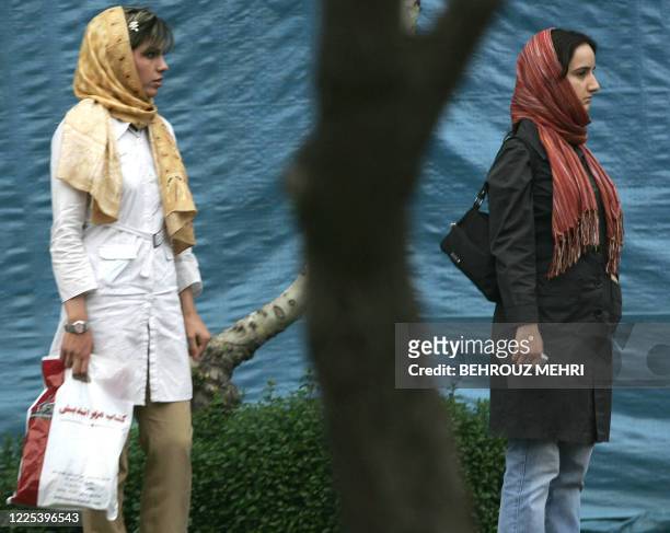 Iranian women wearing modern Islamic fashion wait for a taxi in northern Tehran, 18 April 2006. Iran's police force outlined plans for a renewed...