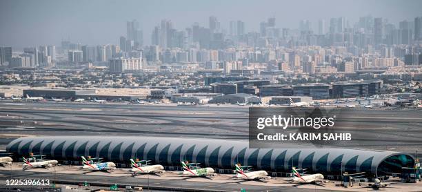 This picture taken on July 8, 2020 shows an aerial view of Emirates aircraft parked on the tarmac at Dubai International Airport , serving the Gulf...