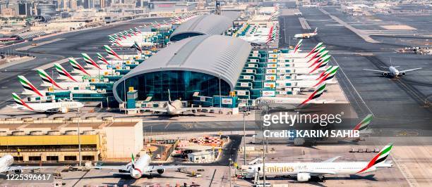 This picture taken on July 8, 2020 shows an aerial view of Emirates aircraft parked on the tarmac at Dubai International Airport , serving the Gulf...
