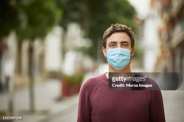 portrait of a man in the city wearing protective face mask - protective face mask stock pictures, royalty-free photos & images