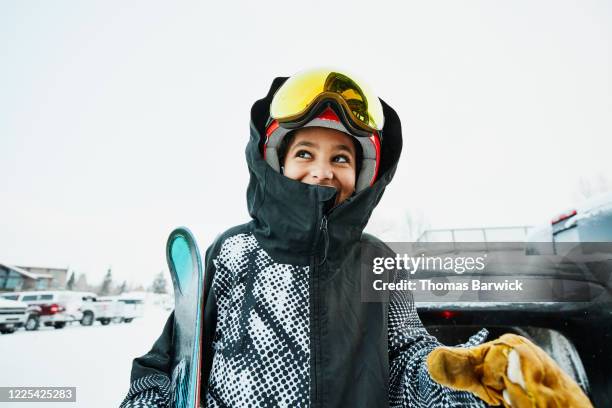 Smiling boy standing in parking lot of ski area before going skiing