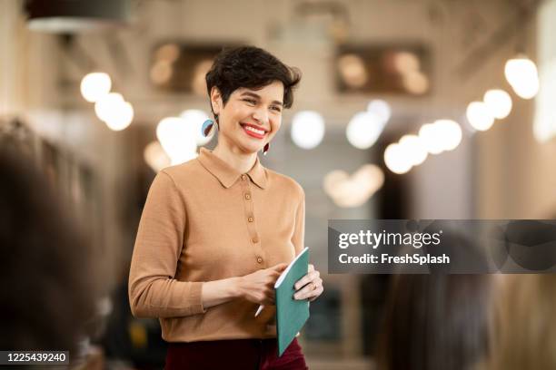 charismatic businesswoman during a business coaching presentation at a modern company - showing imagens e fotografias de stock
