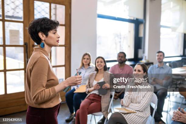 de spreker die van de vrouw presentatie geeft aan businesspeople bij een modern bedrijf - presenter stockfoto's en -beelden