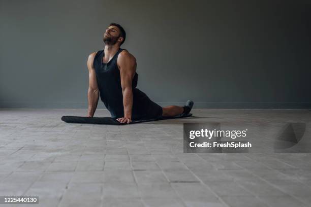 handsome muscular athlete doing yoga alone - stretching in the cobra pose - snakes beard stock pictures, royalty-free photos & images