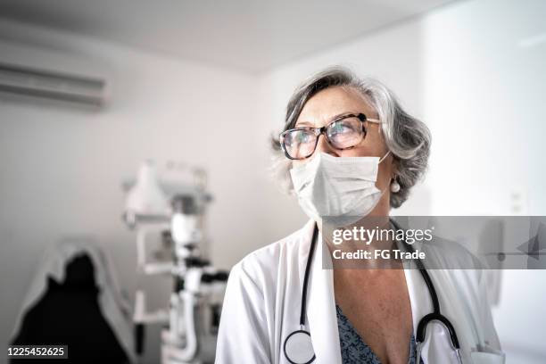 senior female doctor at hospital using protective mask - hospital quarantine stock pictures, royalty-free photos & images