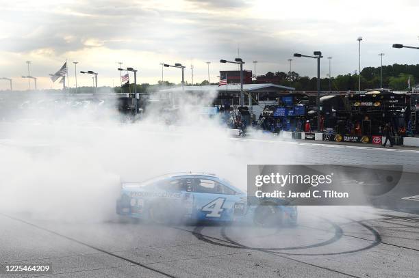 Kevin Harvick, driver of the Busch Light YOURFACEHERE Ford, celebrates with a burnout after winning the NASCAR Cup Series The Real Heroes 400 at...