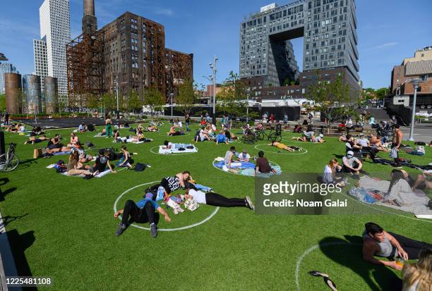 People practice social distancing in white circles in Domino Park in Williamsburg during the coronavirus pandemic on May 17, 2020 in New York City....
