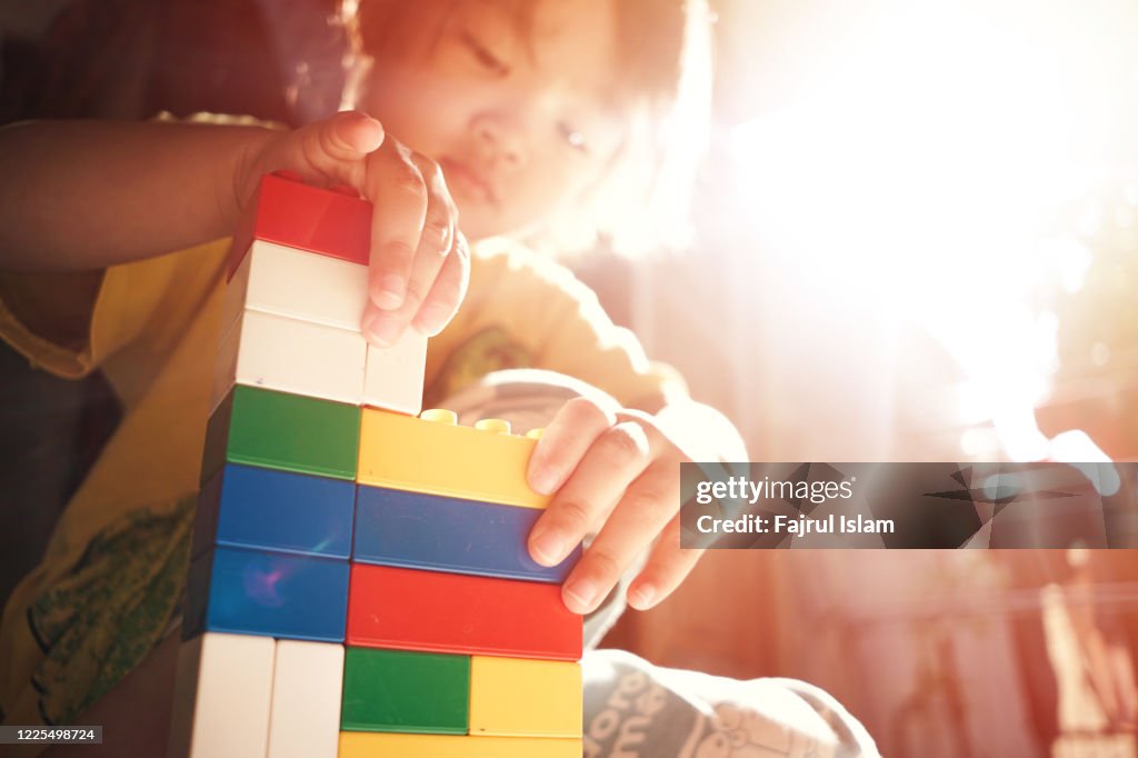 Asian child playing with bricks