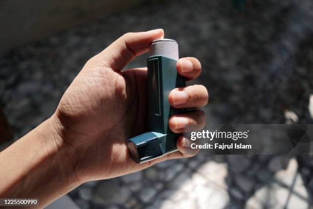 asthma inhaler on hand - inalador-de-alívio-para-asma - fotografias e filmes do acervo
