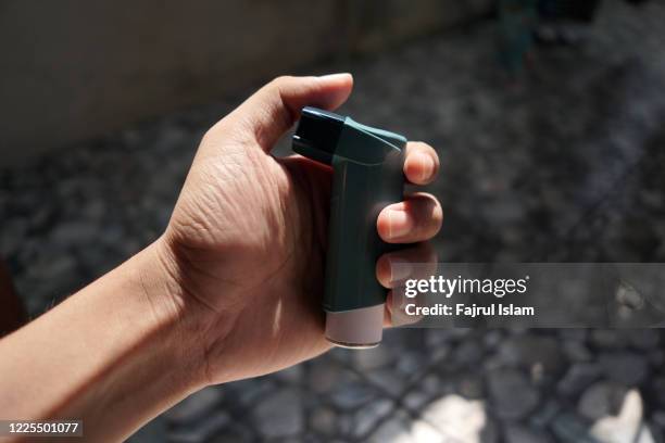 asthma inhaler on hand - inalador-de-alívio-para-asma - fotografias e filmes do acervo
