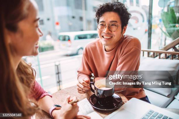 business partners working joyfully together on laptop computer in cafe - report fun stock pictures, royalty-free photos & images