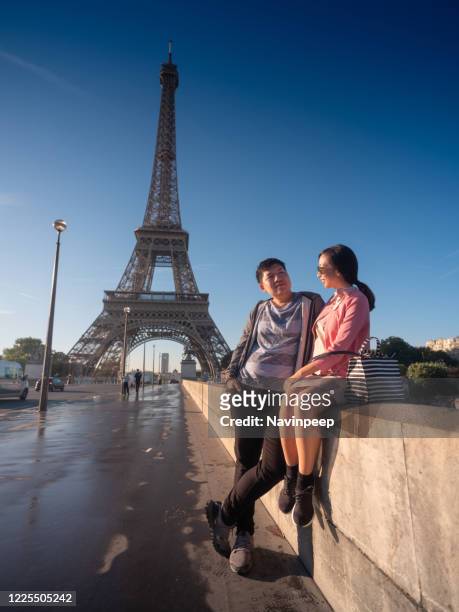 asian couple and eiffel tower, paris, france - couple paris tour eiffel trocadero stock-fotos und bilder