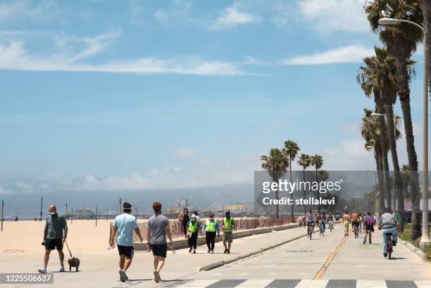 het strand van santa monica met mensen die van een zonnige dag, tijdens covid-19 lopen - boardwalk stockfoto's en -beelden