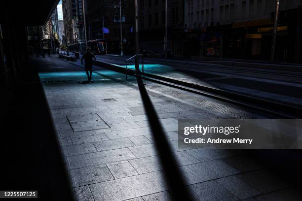 one person running on an empty dark city street during coronavirus lockdown, australia - sydney light rail stock pictures, royalty-free photos & images