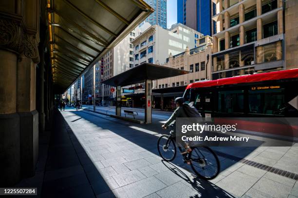 city life with cyclist and red tram, light rail station, australia - sydney trains stock-fotos und bilder