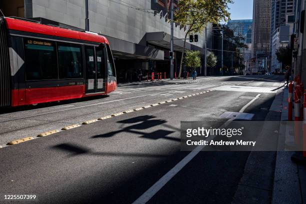 red tram, lightrail on empty city street during coronavirus lockdown, australia - sydney light rail stock pictures, royalty-free photos & images