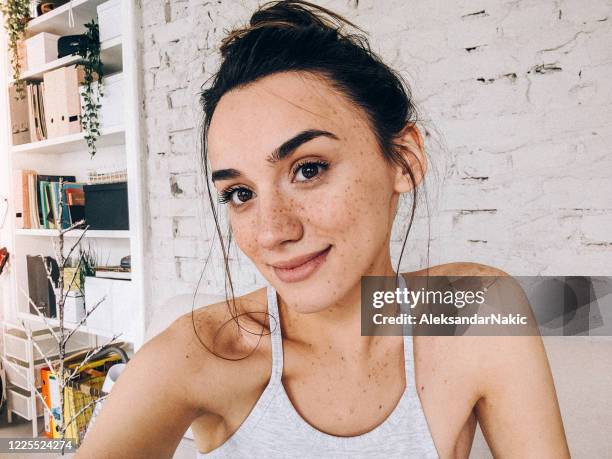 portret van een glimlachende sproetenvrouw - messy bun stockfoto's en -beelden