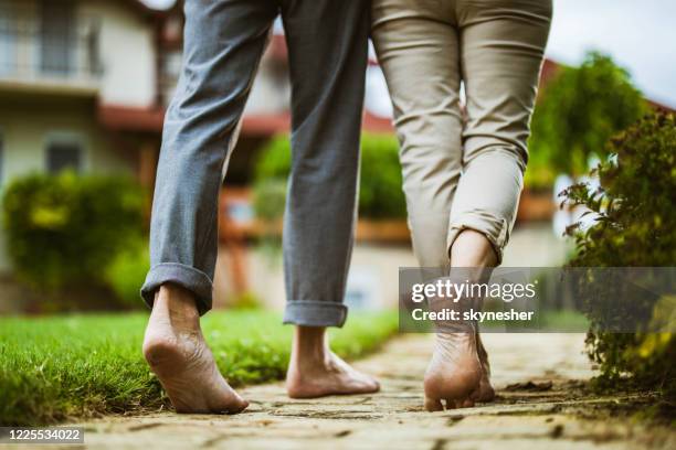 close up of unrecognizable couple walking barefoot in the backyard. - barefoot stock pictures, royalty-free photos & images