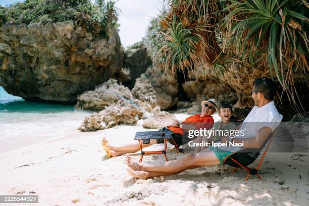 three generation family enjoying beach campsite, okinawa, japan - japan beach stockfoto's en -beelden