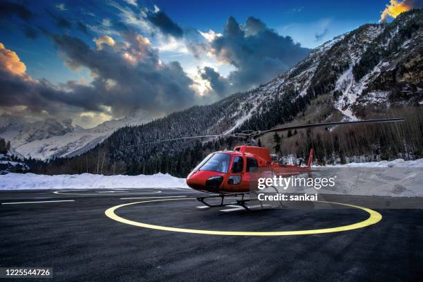 red helicopter on the helipad at sunset. - air ambulance stock pictures, royalty-free photos & images