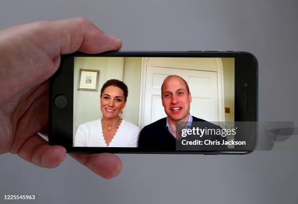 In this photo illustration Prince William, Duke of Cambridge and Catherine, Duchess of Cambridge speak to crisis volunteers on a video-call to mark...