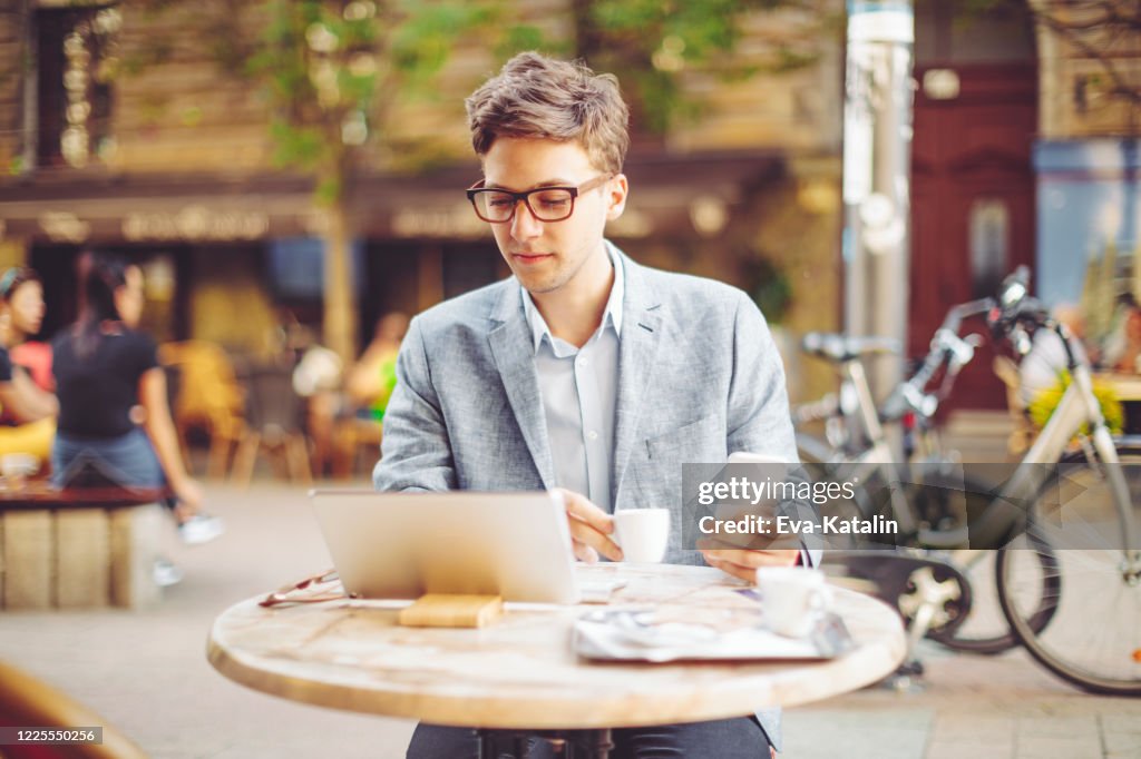 De jonge zakenman heeft zijn lunch in openlucht