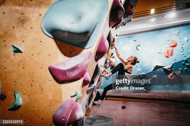 strong millennial woman on boulder climbing - climbing wall stock pictures, royalty-free photos & images