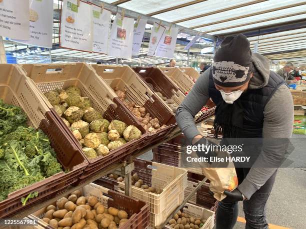 Consommateurs faisant leurs courses avec un masque pour se protéger contre le Covid-19 au marché de Saint-Maur-des-Fossés, France, le 21 mars 2020.