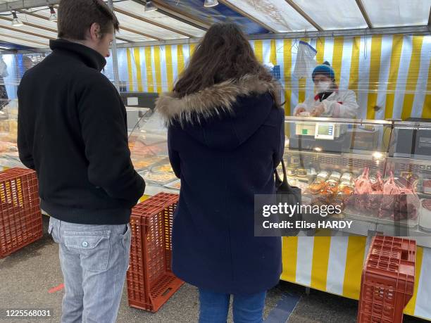 Consommateurs faisant leurs courses et se tenant à 1 mètre d'écart pour se protéger du Covid-19 au marché de Saint-Maur-des-Fossés, France, le 21...