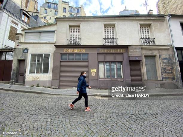 Femme faisant son jogging et portant un masque devant un décor de cinéma "Bière Française supérieure A Hurel" reconstituant des façades datant de la...