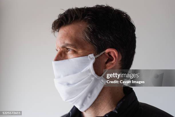 man wearing homemade cloth face mask during covid 19 pandemic. - protective face mask side stock pictures, royalty-free photos & images