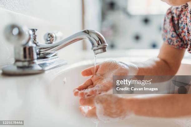 close up view of young child washing hands with soap in sink - bath girl stockfoto's en -beelden
