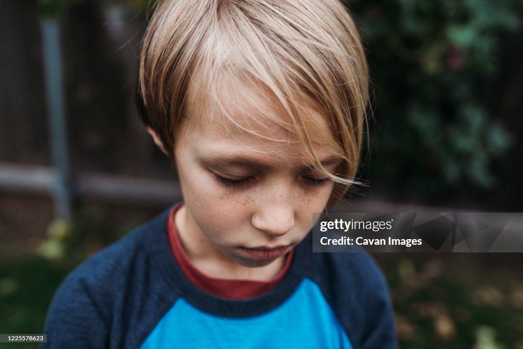 Close up of young boy with eyes closed and freckles