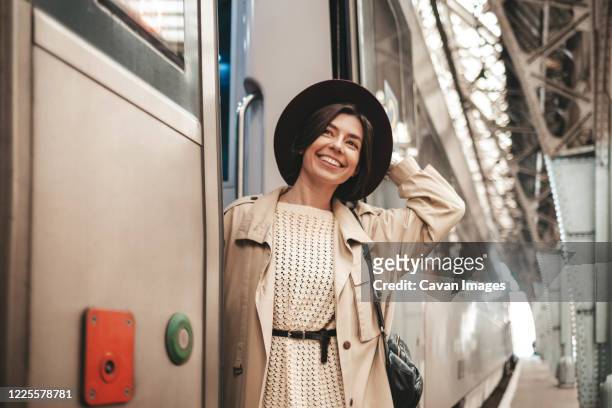 young stylish woman traveler hanging and smiling on the train - arriving late class ストックフォトと画像