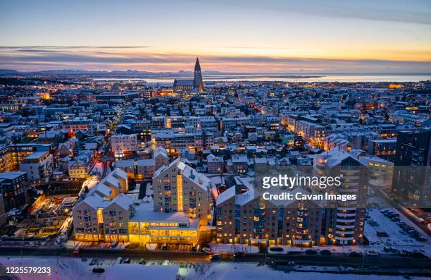 snowy illuminated houses in evening in city - reykjavik winter stock pictures, royalty-free photos & images