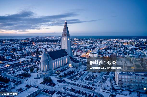 majestic church on snowy city street in evening - reykjavik stock pictures, royalty-free photos & images