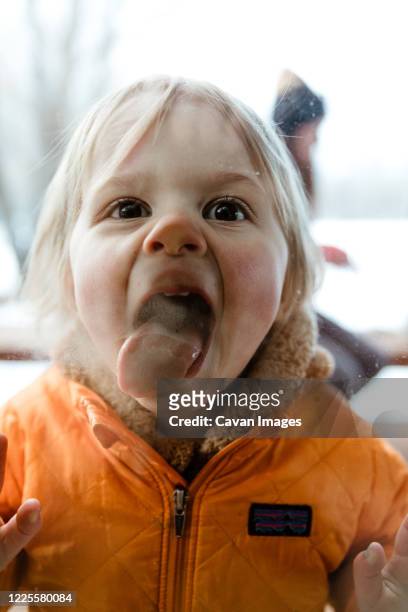 3 year old toddler girl smashes her tongue and face against window - miss you funny stock pictures, royalty-free photos & images