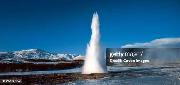 strokkur geysir in south iceland erupting at winter time - geyser ストックフォトと画像