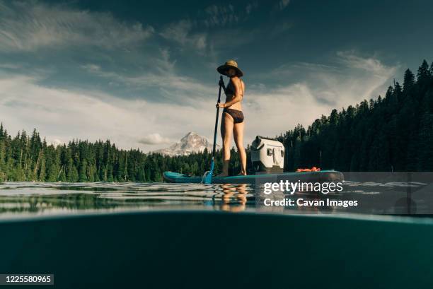 a young woman enjoys a standup paddle board on lost lake in oregon. - oregon stock photos et images de collection