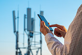 5G communications tower with man using mobile phone