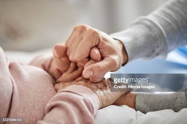caregiver supporting woman during corona outbreak - care stock pictures, royalty-free photos & images
