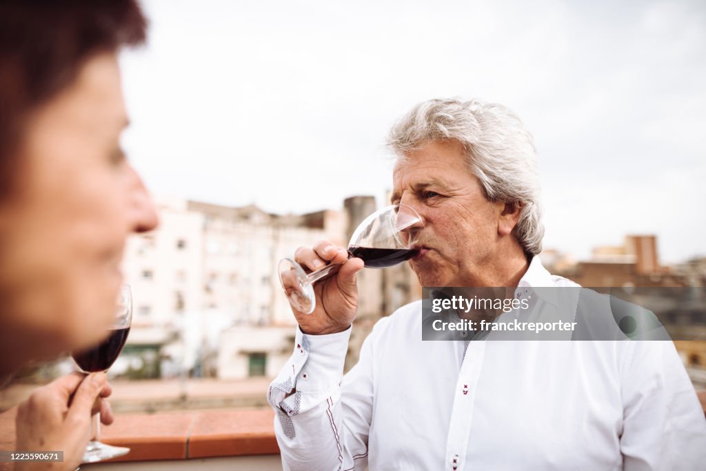 Reife erwachsene Paar tun einen Aperitif auf dem Balkon