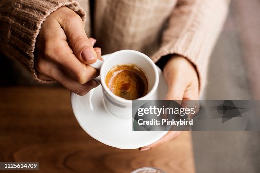 De Kop van de koffie, De handen die van de Dame de Kop van de Koffie houden, Vrouw die een witte mok, Espresso in witte kop houdt De Kop van de koffie, De handen die van de Dame de Kop van de Koffie houden, Vrouw die een witte mok, Espresso in witte kop houdt
