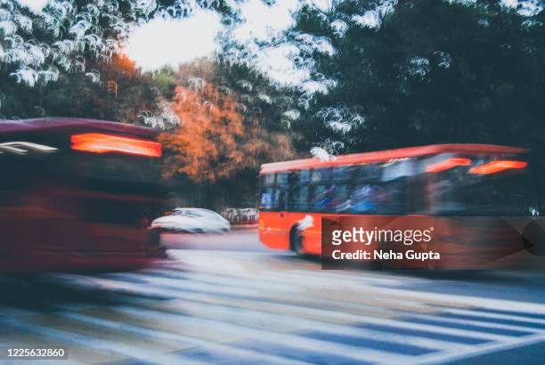 central delhi (india) at dusk with buses driving through - express photos et images de collection