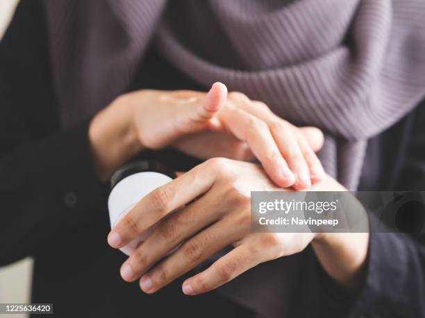 beautiful islamic woman applying hand cream - hand cream stock pictures, royalty-free photos & images