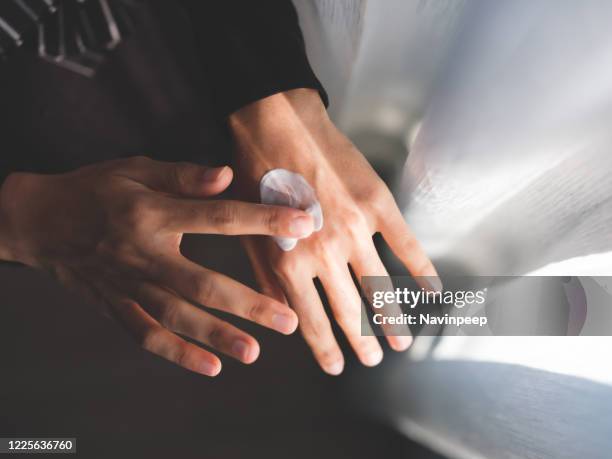 applying hand cream onto back of hand - dorso mano fotografías e imágenes de stock