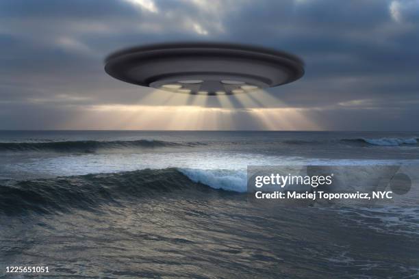 view of the flying saucer (ufo) over the ocean. - untertasse stock-fotos und bilder