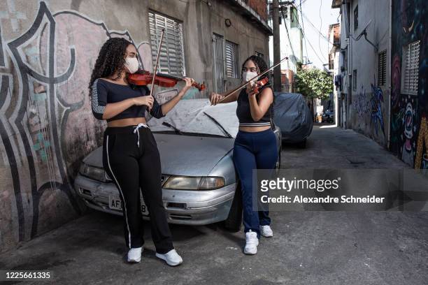 Luciana Beatriz Lira and Gabriela Karine Lira , twin sisters, 18 years old, play the violin in Heliopolis amidst the coronavirus pandemic on July 7,...