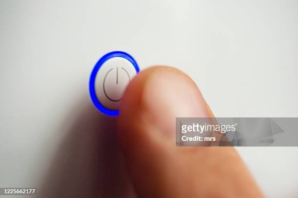 hand pressing power button - botton stock-fotos und bilder